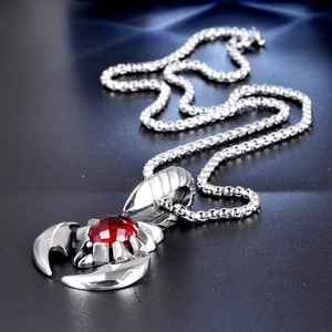 Detailed close-up of a silver stainless steel scorpion pendant with a red gemstone eye