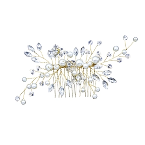 Detailed close-up of bridal hair comb with gold wires, white pearls and clear crystals