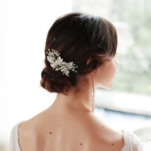 Detail of silver bridal hair comb with pearls and matching long fringe earrings on model
