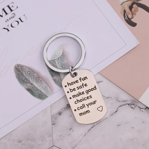 Silver metal keychain with 'Have Fun Be Safe' engraving on marble background