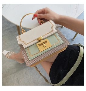 Detail of sage green and beige crossbody bag with golden handle and woven texture