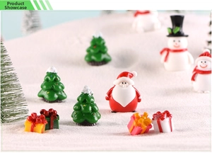 Miniature Christmas set with Santa, snowman, and tree on snow landscape scene