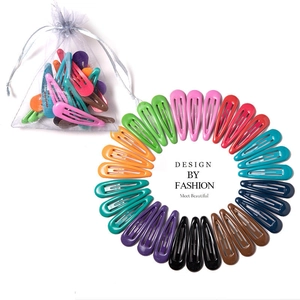 Set of colorful snap hair clips in candy colors arranged with a white organza gift bag