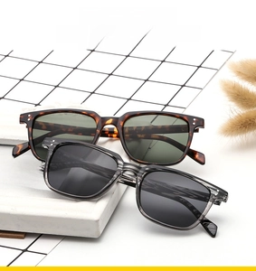 Close-up of retro square sunglasses featuring rivet details and stylish tortoiseshell frames