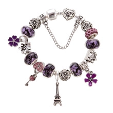 Detailed close-up of purple unicorn charm bracelet with Eiffel Tower and heart pendants