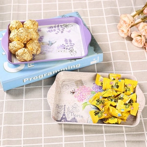 Detail of vintage metal snack trays with floral patterns and sturdy side handles