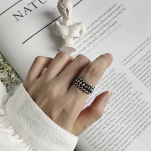 Macro view of retro 925 silver braided chain ring on hand with artistic background