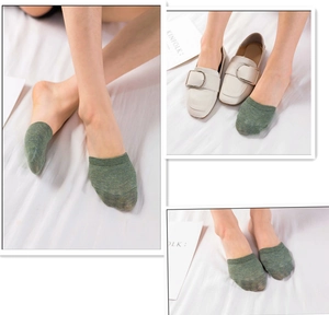 Detail of dark green cotton half socks worn with white loafers for an invisible look