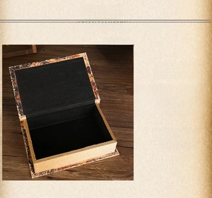 Dettaglio di scatola portaoggetti vintage a forma di libro con interno in tessuto nero