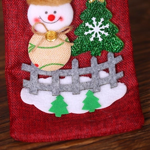 Red burlap Christmas wine bottle cover featuring a snowman and sequin tree decoration