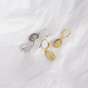 Detail of S925 sterling silver hoop earrings with gold and silver Virgin Mary pendants
