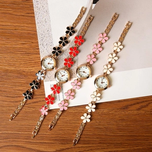 Detail view of four elegant quartz flower watches with colorful enamel petals and gold straps