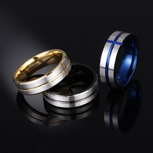 Three brushed stainless steel cross rings in gold, black, and blue with mirror reflections