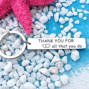 Silver stainless steel keychain with 'Thank You For All That You Do' on beach sand