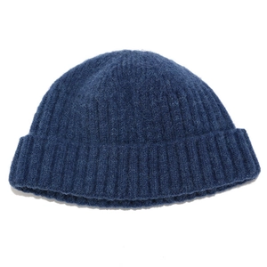 Close-up of dark blue knit beanie with thick mohair texture and ribbed cuff detail