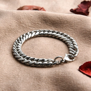 Detailed view of silver polished stainless steel Cuban link bracelet with lobster clasp
