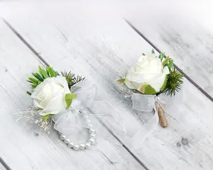 Detailed set of white silk rose boutonniere and wrist corsage with pearl beads