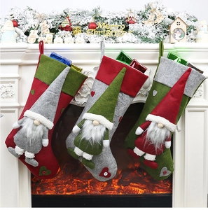 Trois chaussettes de Noël avec gnomes suspendues près d'une cheminée chaleureuse