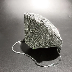 Macro detail of diamond-shaped evening clutch with silver crystals and metal chain
