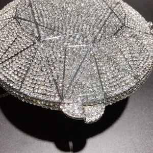 Detailed close-up of geometric silver crystal clutch bag with shimmering rhinestones