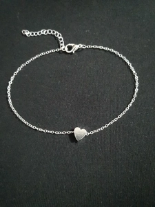 Macro shot of silver beaded chain with heart pendant and adjustable lobster clasp closure