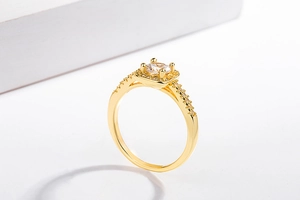 Macro shot of gold plated halo ring with round center diamond and side pave stones