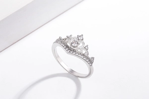 Macro shot of silver crown ring with heart-shaped cutout and pavé set cubic zirconia stones