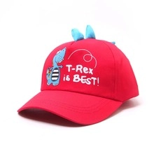 Detailed view of red cotton baseball cap featuring blue cartoon dinosaur and T-Rex embroidery