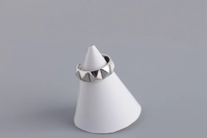 Detailed view of S925 sterling silver pyramid stud ring on a white display stand