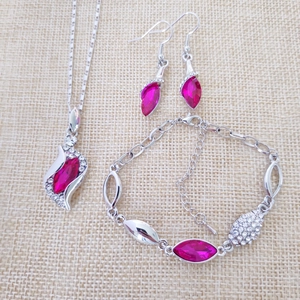 Detailed flat lay of angel crystal necklace, earrings, and bracelet with pink gemstones