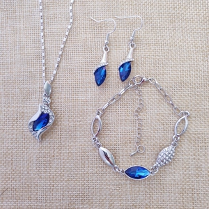 Detailed set of silver jewelry with blue crystals, including necklace and earrings