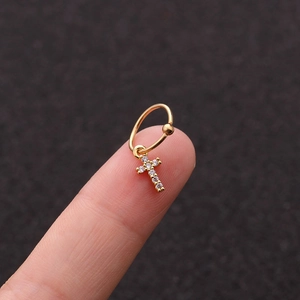 Dettaglio dell'orecchino a cerchio d'oro con pendente a croce in zircone lucido