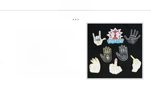 Detail view of zinc alloy punk rock hand pins with colorful enamel and lettered patterns