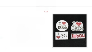 Macro detail of zinc alloy pins with I Love Cats and I Love Doll enamel designs