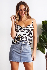 Detail of leopard print satin camisole top paired with distressed denim skirt for summer