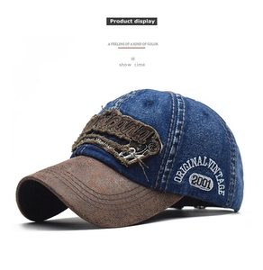 Detail of vintage denim baseball cap with embroidery and distressed leather brim texture