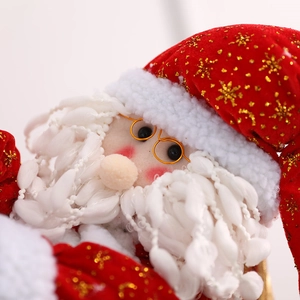 Close-up of Santa Claus doll with golden sequins and round glasses for Christmas decor