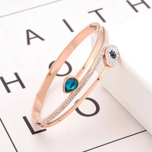 Bracelet jonc ouvert or rose avec œil bleu et pierre en forme de goutte bleue