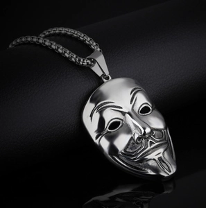 Detailed macro shot of silver hip-hop necklace with Guy Fawkes mask pendant and metal chain