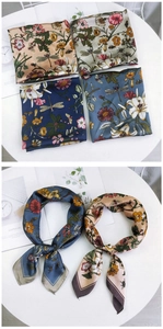 Detail of floral silk scarves with dragonfly prints in navy and champagne colors
