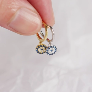 Macro detail of S925 silver evil eye hoop earrings with blue zircon and pavé setting