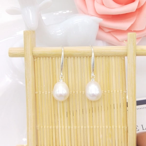 Detail of drop-shaped freshwater pearl earrings on S925 silver hooks with floral decor