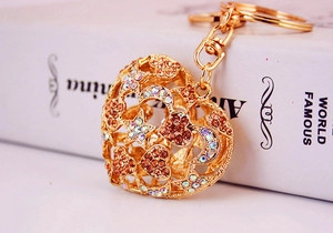 Macro shot of gold alloy heart keychain with colorful rhinestones and moon star patterns