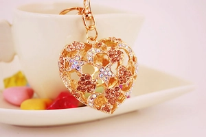 Macro shot of gold-plated hollow heart keychain with sparkling rhinestones and stars