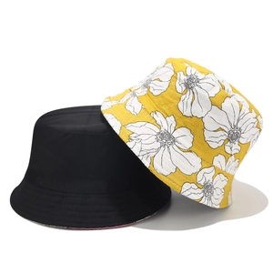 Detail von wendbaren Baumwoll-Fischerhüten in Schwarz und Gelb mit Blumenmuster
