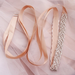 Dettaglio della cintura da sposa con nastro champagne e ricami in strass argento