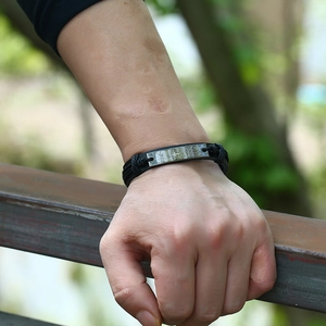Men's vintage black braided leather bracelet with rectangular metal plate on wrist