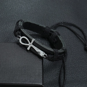 Detail of black woven leather bracelet with metal Ankh charm and adjustable knot