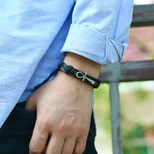 Men's black braided leather bracelet with silver Ankh cross pendant on wrist