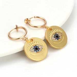 Detail showing golden hoop earrings with blue and white Turkish evil eye glass charms